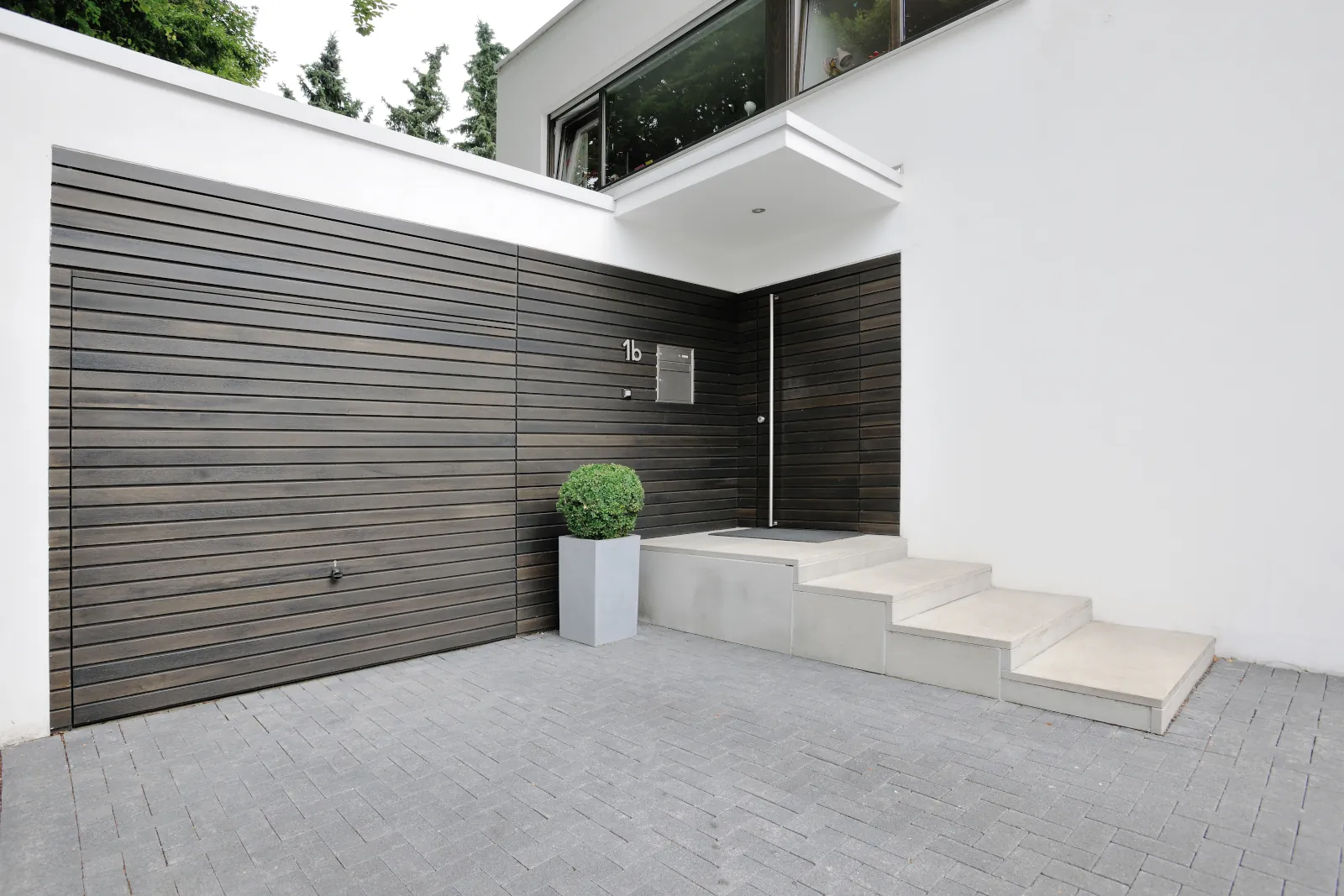 Fassadenbündiges Schwingtor von Hörmann passend zu Fassade und Haustür